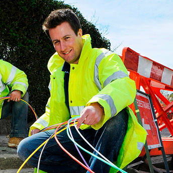 Workers with fibre coil on the road.